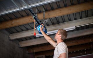 Garage door repair man fixing garage door opener - Garage Harmony