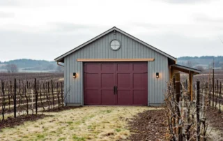 Insulated garage door on wine storage building surrounded by vineyard rows in McMinnville's Willamette Valley