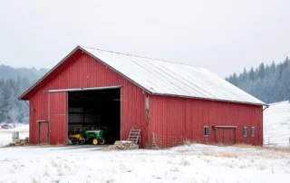 Red metal barn with reinforced garage door system in snowy Amboy foothills designed for agricultural storage