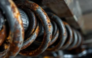 Weathered garage door torsion spring showing rust and wear patterns from Pacific Northwest moisture exposure