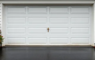 Garage door with mix of new replacement panels and aged original panels showing contrast in wear and condition