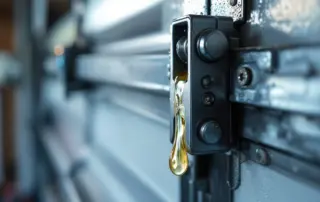 Garage door roller and hinge assembly with fresh lubricant applied to metal components