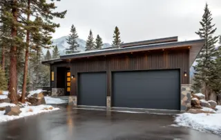 Contemporary garage door on mountain home with snow and natural stone in Central Oregon winter setting