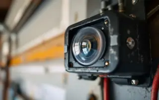 Garage door photo-eye safety sensor with mounting hardware and wire connections